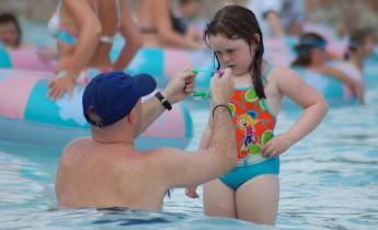 padre e figlia in piscina pubblica