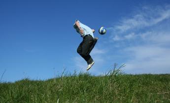 ragazzo che gioca a calcio sull'erba
