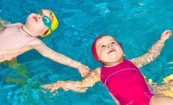 bambine che galleggiano in piscina