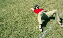 Ragazzo sdraiato su campo da calcio